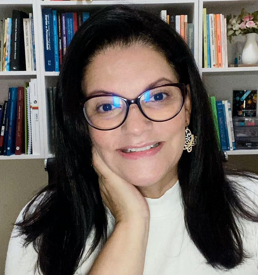 Sofia Nantes, psicóloga, na frente da estante de livros do consultório